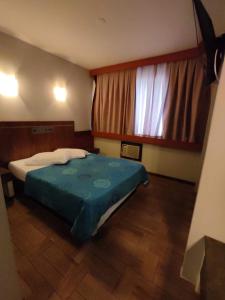 库里提巴艾鲁库里提巴酒店的一间卧室设有一张床和一个大窗户