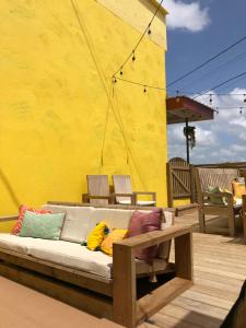 圣伊格纳西奥Yellow Belly Backpackers的天井上配有带色彩缤纷枕头的沙发