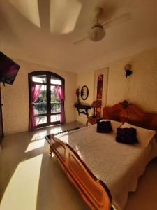 卡波布里奥Pousada Chez Moi的一间卧室设有一张大床和一个窗户。