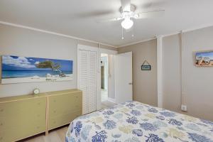 富丽海滩SeaEscape的一间卧室配有一张床和吊扇