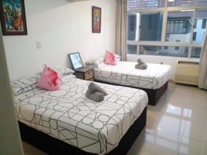 德班Sandz accomodation at 108的带窗户的客房内的两张床和粉红色枕头
