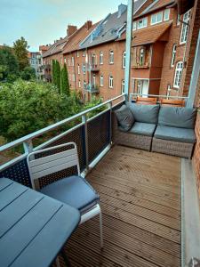 爱尔福特Appartement OTTO I - Erfurt Zentrum的大楼内的阳台配有沙发和椅子