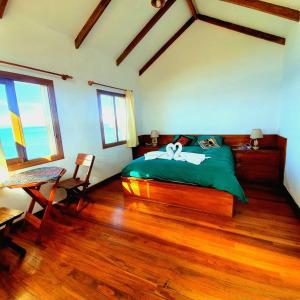 Comunidad YumaniEcolodge El descanso的一间卧室设有绿色的床,铺有木地板