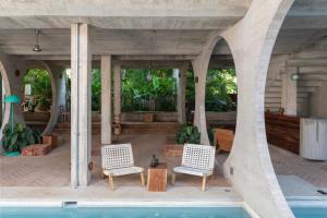埃斯孔迪多港Casa TO的一个带两把椅子的庭院和一个游泳池