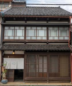 金泽Machiya Guest House Carta的一座带窗户和屋顶的亚洲房屋