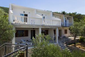 普特尼科维奇Apartments by the sea Zuronja, Peljesac - 14095的带阳台和楼梯的大型白色房屋