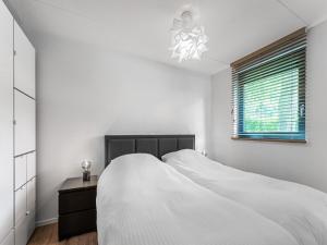 洛赫姆Modern holiday home in Lochem with private garden的白色的卧室设有床和窗户