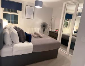 梅登黑德Super Luxe Central Maidenhead Apartment的一间卧室配有带枕头和镜子的床