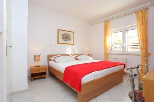 杜埃Apartments by the sea Duce, Omis - 16406的一间卧室配有一张带红色毯子的床