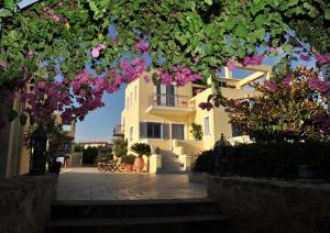 爱琴娜岛菲斯狄吉思假日公寓酒店的前面有粉红色花的建筑