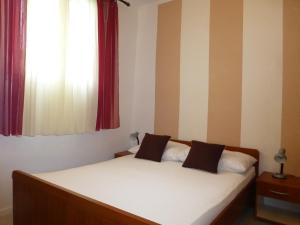维利伊兹Apartment Mali Iz 16535b的一间卧室配有一张带白色床单的床和一扇窗户。