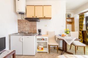 莫托文Apartments with a parking space Motovun, Central Istria - Sredisnja Istra - 14160的厨房配有小桌子和白色冰箱。