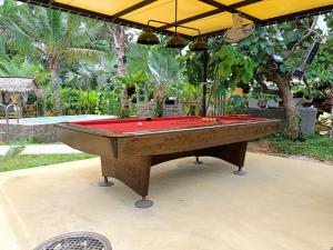 班佩Barong Resort的庭院里一张红色遮盖的台球桌