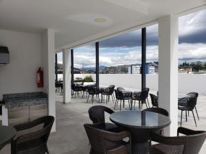 基多Hermoso departamento, céntrico y tranquilo的庭院配有桌椅和窗户。