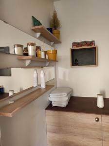 鲁昂Logement entier+ jardin privé et parking 2places的浴室设有木制架子、水槽和毛巾