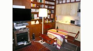 巴黎乐38，鲁圣路易斯恩里勒酒店的厨房配有桌椅和电视。
