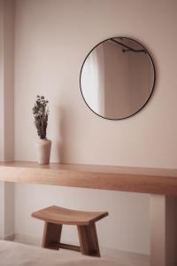 阿菲托斯Om Living Afitos的墙上的圆镜子,木桌