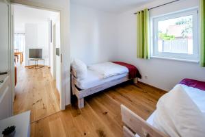 萨勒河畔瑙姆堡Chalet Altalmrich的客房设有两张床、一个窗口和一张沙发