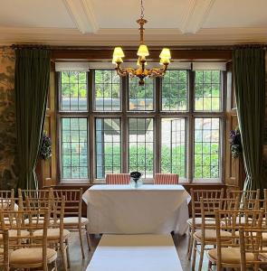 阿什伯恩Wildhive Callow Hall的一间带桌椅和窗户的用餐室