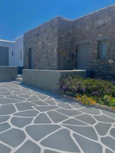 米克诺斯城Aegean Hospitality的鲜花建筑前的石头走道