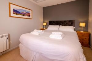 查普尔斯提莱Langdale Retreat的卧室配有带毛巾的大型白色床