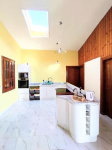 Villaggio TedeschiLa Casa的一间设有白色橱柜和天窗的大厨房