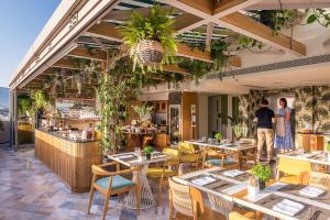 雅典Niche Hotel Athens的一间带桌椅的餐厅和一间酒吧