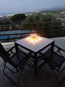 Villaggio TedeschiLa Casa的阳台配有一张桌子和两把椅子,配有灯
