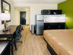 查尔斯湖Quality Inn & Suites Lake Charles South的酒店的客房 - 带一张床、一张书桌和一台冰箱