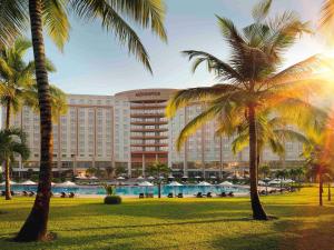 阿克拉阿克拉瑞享大使酒店的棕榈树在游泳池前的酒店