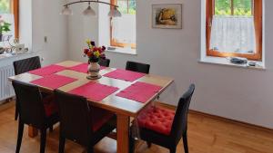 LieserhofenMalerisches Bauernhaus的一张带红色餐巾和花瓶的餐桌