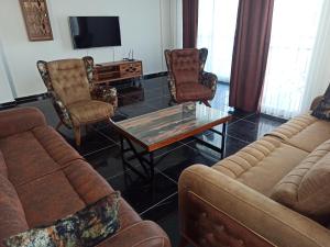 库萨达斯Begonville Villas Ladies Beach的带沙发和咖啡桌的客厅