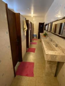 拉热斯Pousada Irmãs Franciscanas的浴室设有一排盥洗盆和红色垫子