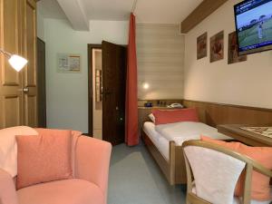 昂特雷申巴赫昂特雷卡普芬哈德特尔姆勒兰德酒店的一间设有两张床、一台电视和椅子的房间