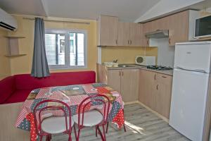 帕米耶阿帕米亚露营地的一个带桌子和红色沙发的小厨房