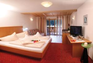 马尔泰洛Hotel Restaurant Waldheim的酒店客房,配有床和电视