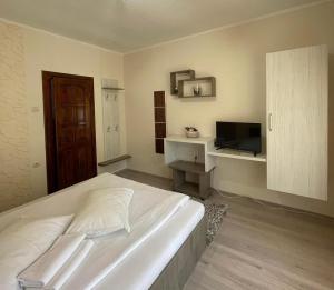 索瓦塔Pensiunea Aby的卧室配有白色的床和电视。
