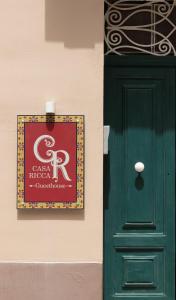 圣保罗湾城Casa Ricca的绿门旁墙上的标志