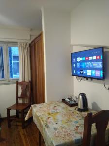 圣卡洛斯-德巴里洛切Astoria Patagonia habitaciones privadas的一间房间,墙上设有一张桌子和一台电视机