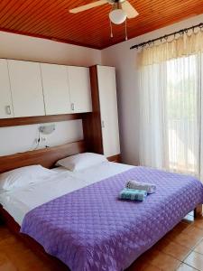 坎普尔House Branka的一间卧室配有一张带紫色棉被的床