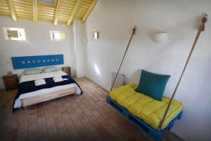维拉多比斯坡Casa Amado, Aldeia da Pedralva的一间卧室配有一张床和两个秋千
