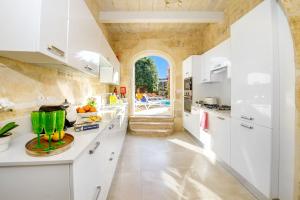 纳杜尔Sulda Brill的一间厨房,配有白色的橱柜和大窗户