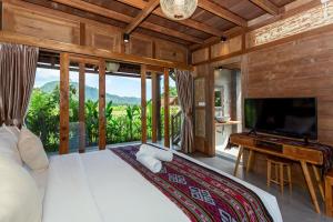 SilebengKubu Sakian Villa的一间卧室配有一张大床和一台平面电视