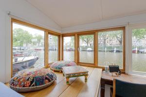 阿姆斯特丹The Amsterdam Houseboat Family - de Jordaan的船屋设有窗户、桌子和长凳