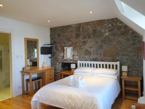 托伯莫里Harbour view的一间卧室设有一张床和石墙