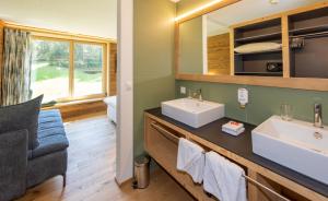 达沃斯凯斯勒库尔姆酒店的浴室设有2个水槽和镜子