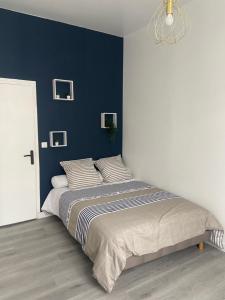 卢维耶Appartement Centre ville Louviers的一间卧室设有一张蓝色墙壁的大床