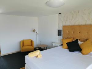 LajitaChabela's water wall的卧室配有白色的床和黄色椅子