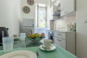 米兰CityLife, Fiera City, MiCo & San Siro Apartment的厨房配有一张桌子,上面放着一碗水果