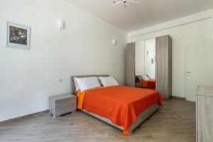 米兰CityLife, Fiera City, MiCo & San Siro Apartment的一间卧室配有一张带橙色毯子的床